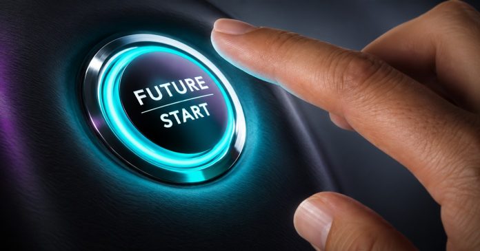 A hand poised above a glowing teal button labeled Future Start on a dark surface.